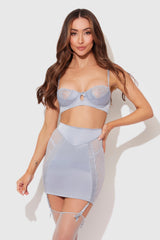 Woman wearing a light blue lingerie set on a white background