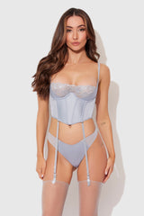 Woman wearing a light blue lingerie set on a white background